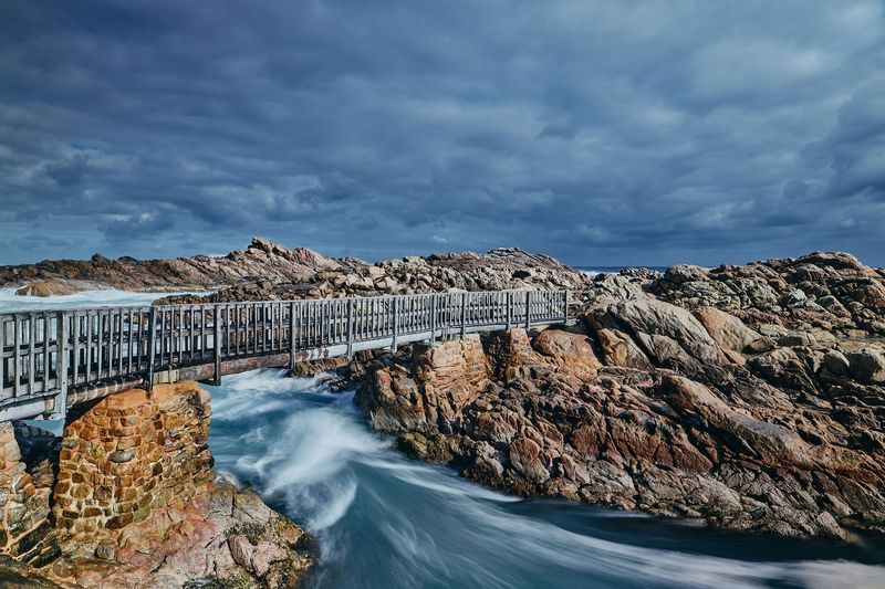 Timber bridge over rushing water and granite, Canal Rocks, Yallingup