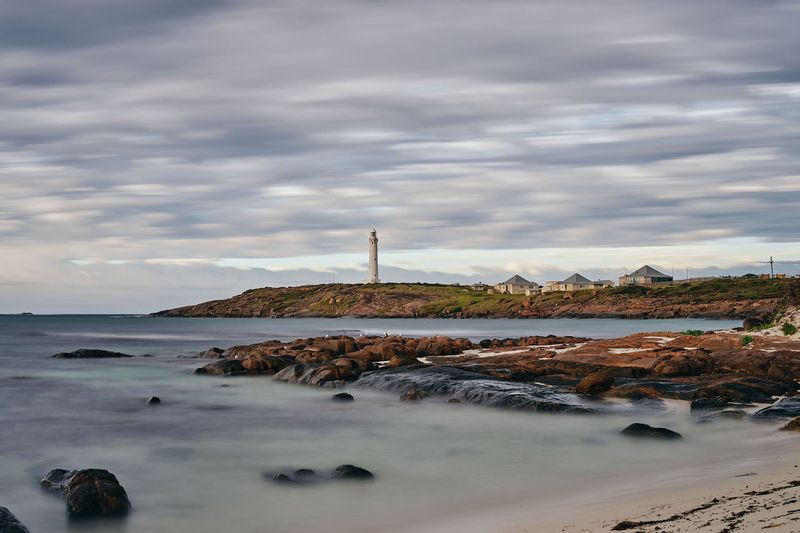 White lighthouse on a rocky headland at dusk, Lighthouse, South West