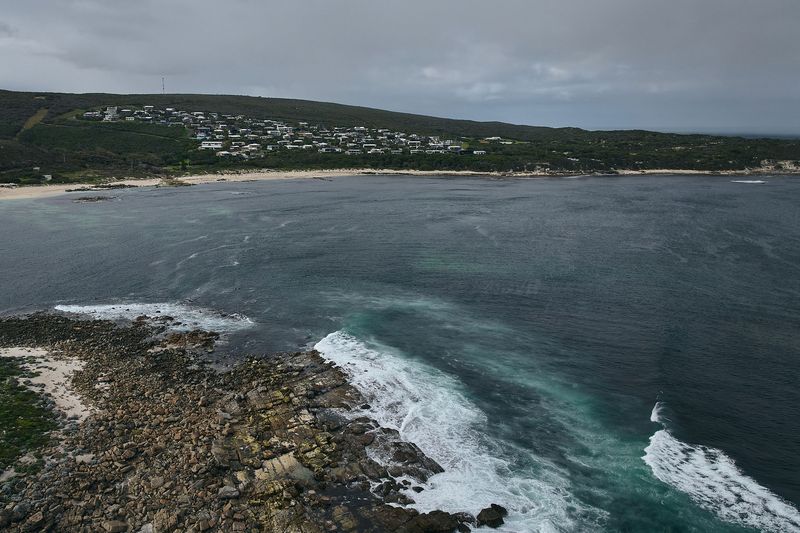 Rocky bay and rolling swell under grey cloud, Gracetown